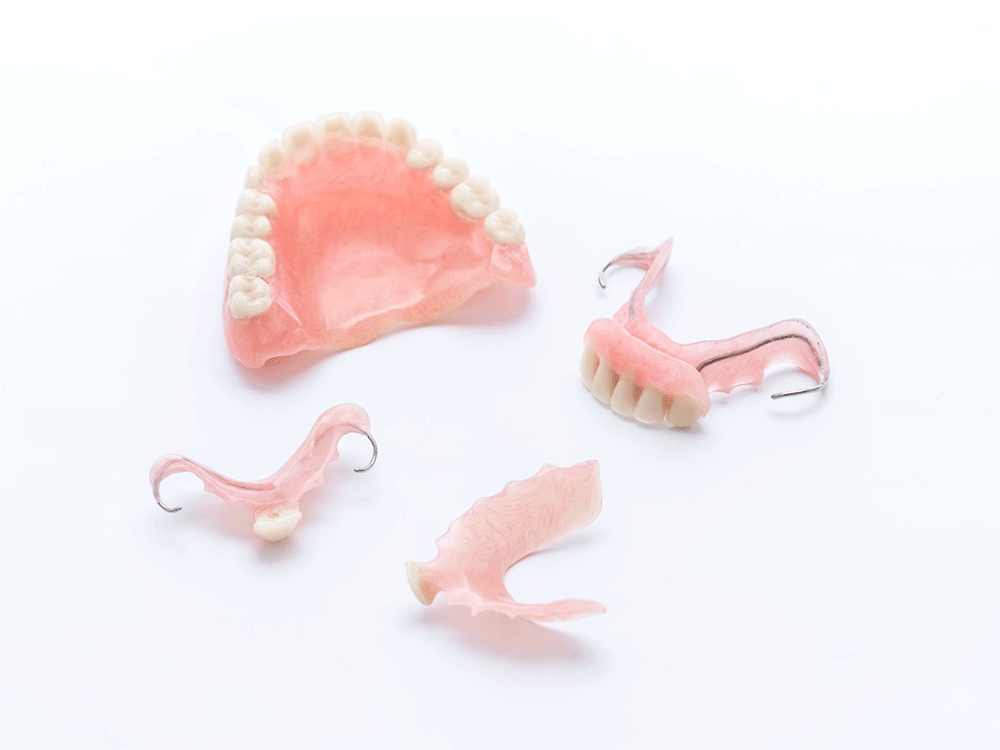 various types of dentures laid out on a white background